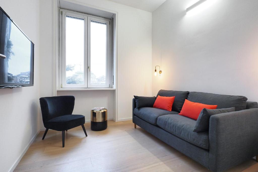 a living room with a couch and a chair at Contempora Apartments - Turati 3 One Bedroom Apartment in Milan