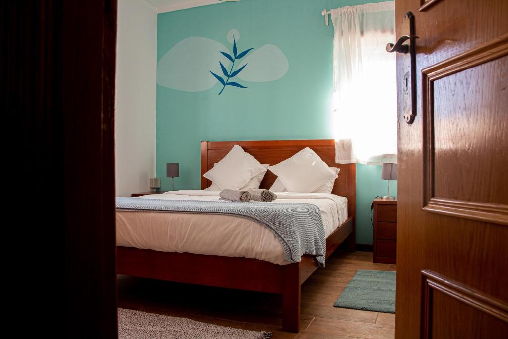 a bedroom with a bed with a blue wall at Baleal GuestHouse in Baleal