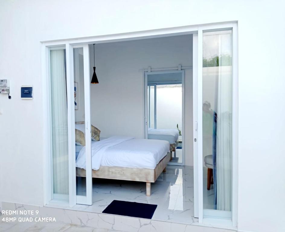 a bedroom with a bed and sliding glass doors at Villa Mosel Bali in Banjar