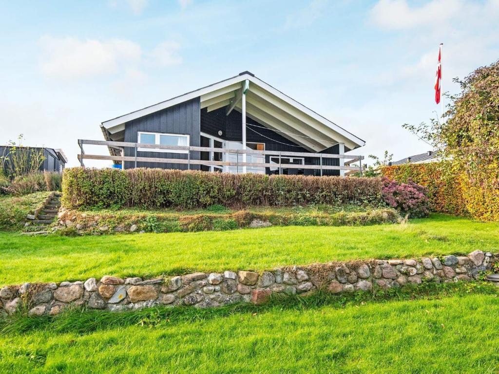 a house on a hill with a stone wall at 6 person holiday home in Børkop-By Traum in Børkop