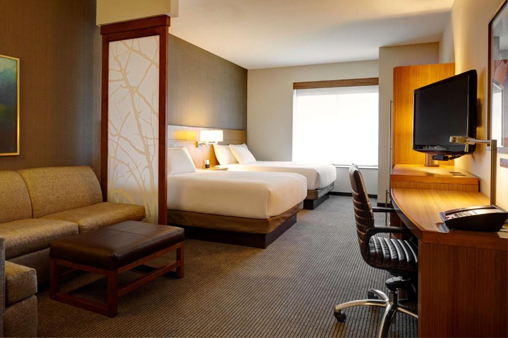 a hotel room with two beds and a television at Hyatt Place Lansing-East in Lansing