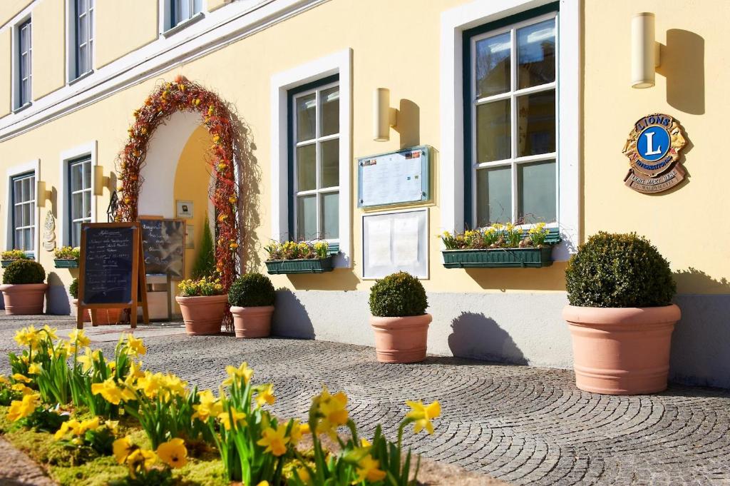 a building with an arch and flowers in front of it at Hotel & Restaurant Stern in Gmünd