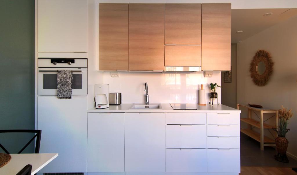 uma cozinha com armários brancos e um frigorífico branco em City Home Aapeli em Kuopio