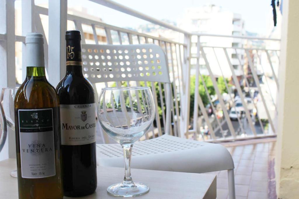 una botella de vino y una copa en una mesa en Lloret Centre Apartment, en Lloret de Mar