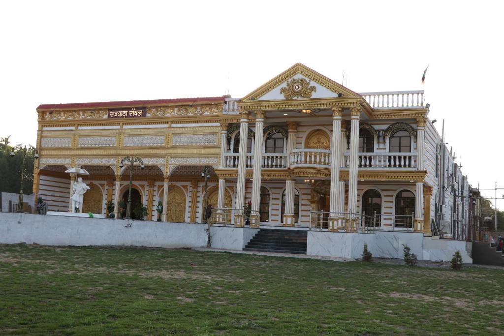 ein großes gelbes Gebäude mit einer Treppe davor in der Unterkunft RAJWADA RESORT & HOTEL in Raipur