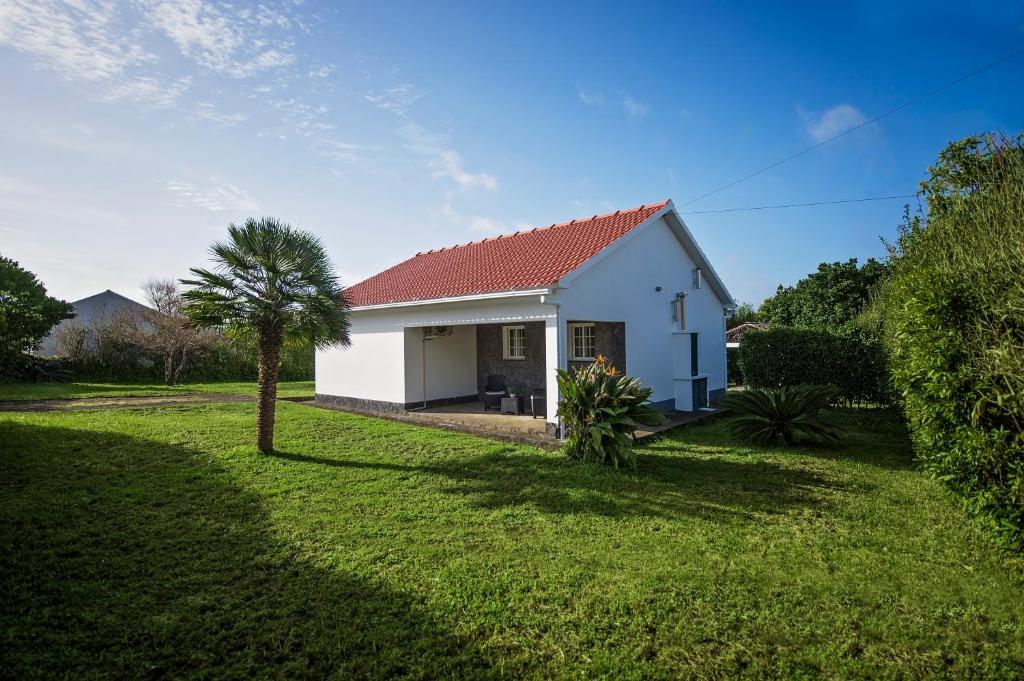 a white house with a red roof at Garden Oasis in Capelo