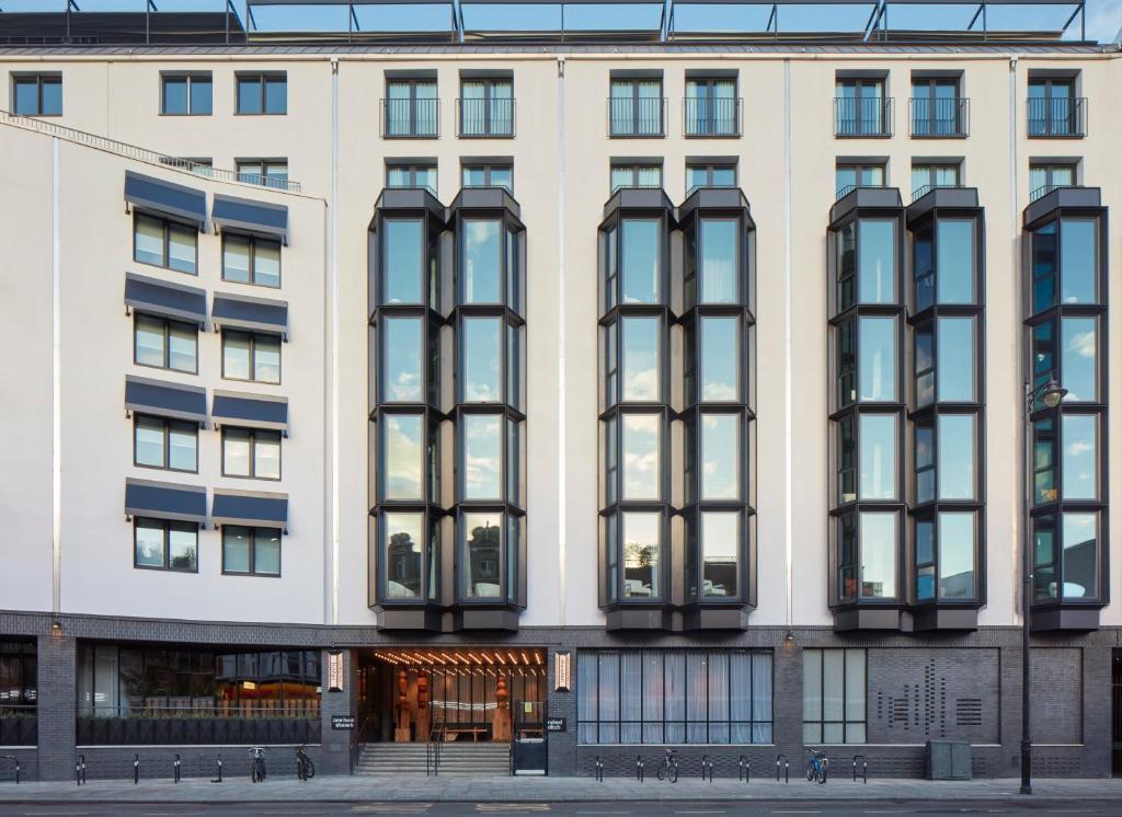 - un grand bâtiment blanc avec des fenêtres noires dans l'établissement One Hundred Shoreditch, à Londres