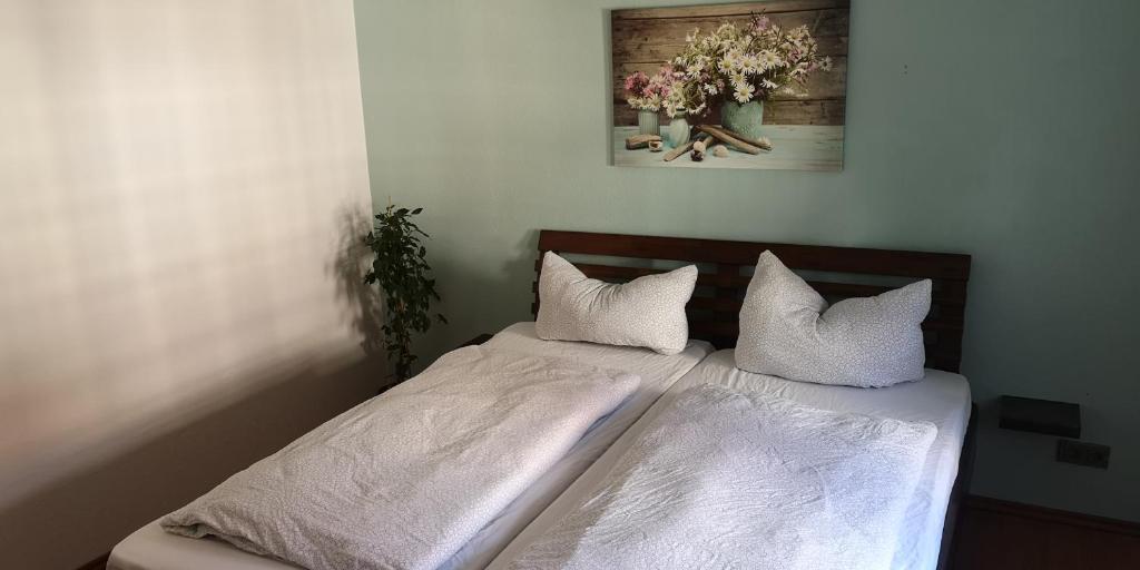a bed with white sheets and pillows in a bedroom at Ferienwohnung/Monteurwohnung im Herzen von Ahnatal in Weimar