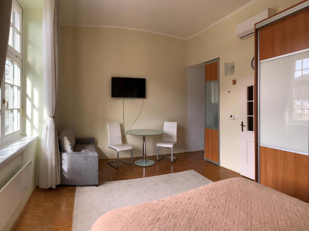 a bedroom with a bed and a table and chairs at Apartment 19 Vila Golf Nice Vacation in Rogaška Slatina