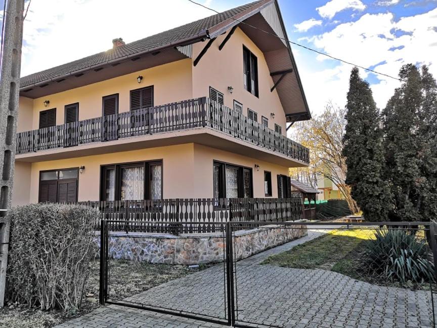 une maison avec une clôture devant elle dans l'établissement Kupa Villa, à Balatonboglár