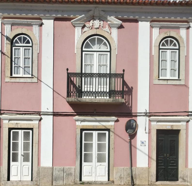 a pink and white building with a balcony at Casa Dorothea in Cercal