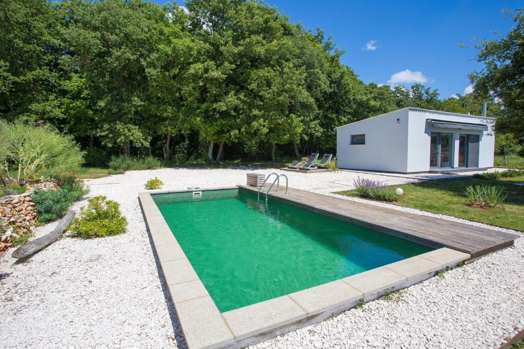 a swimming pool in a backyard with a tiny house at Cottage House Loborika with Pool in Loborika