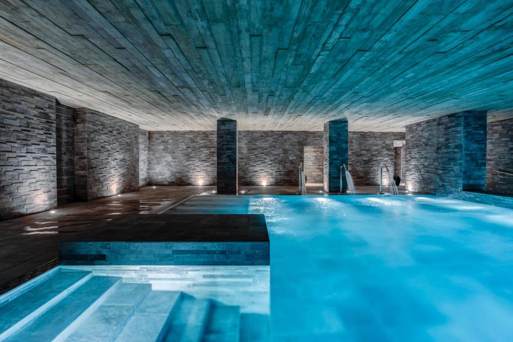 - une grande piscine d'eau bleue dans un bâtiment dans l'établissement Hôtel Lyon Métropole, à Lyon