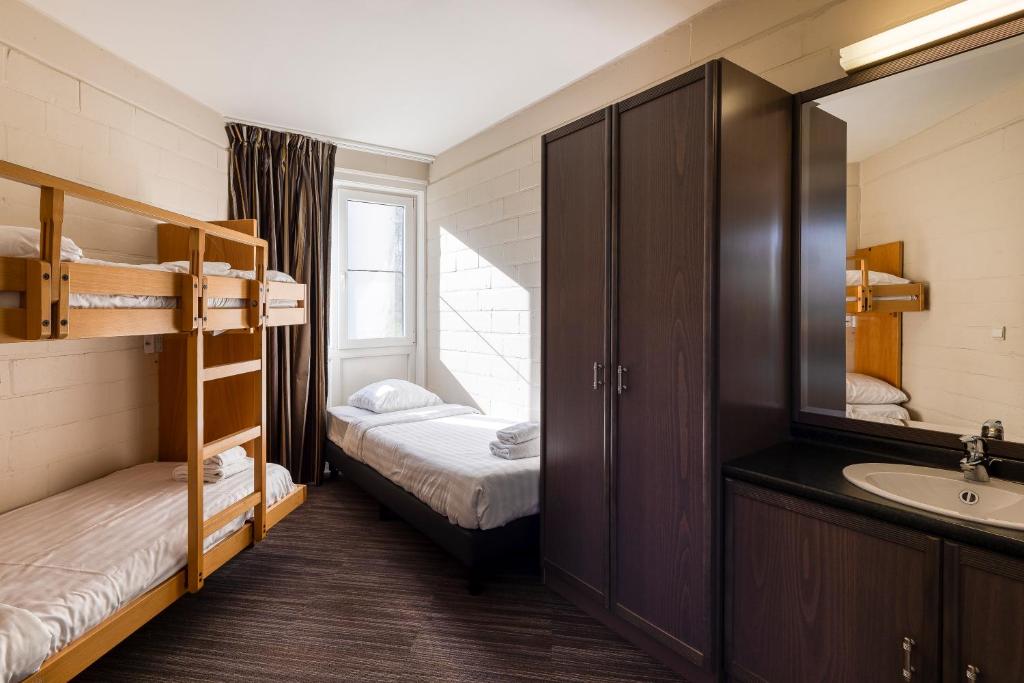 a room with a bunk bed and a sink and a bathroom at Corsendonk Duinse Polders in Blankenberge