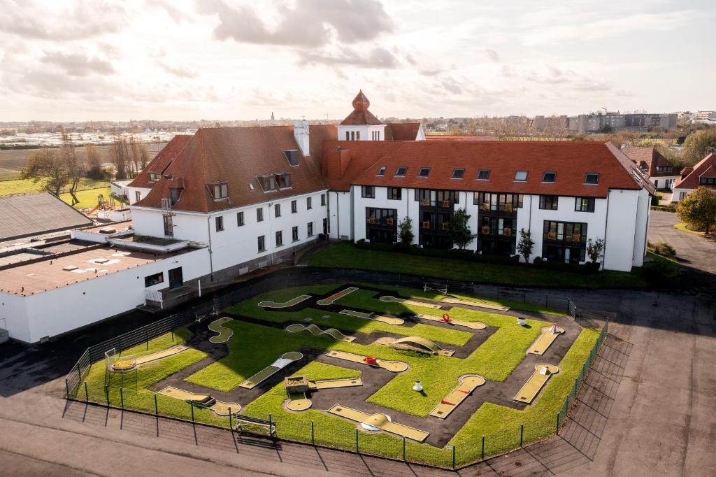 an aerial view of a building with a large yard at Corsendonk Duinse Polders in Blankenberge