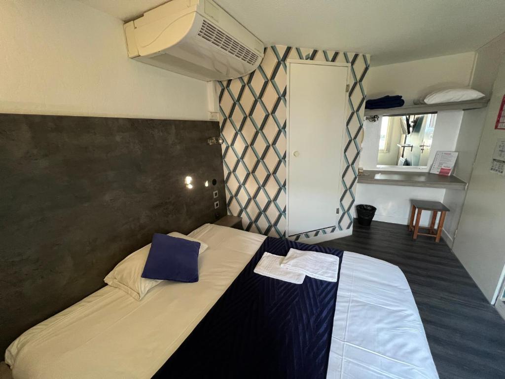 a bedroom with a bed and a dresser at Fasthotel Le Mans in Saint-Saturnin