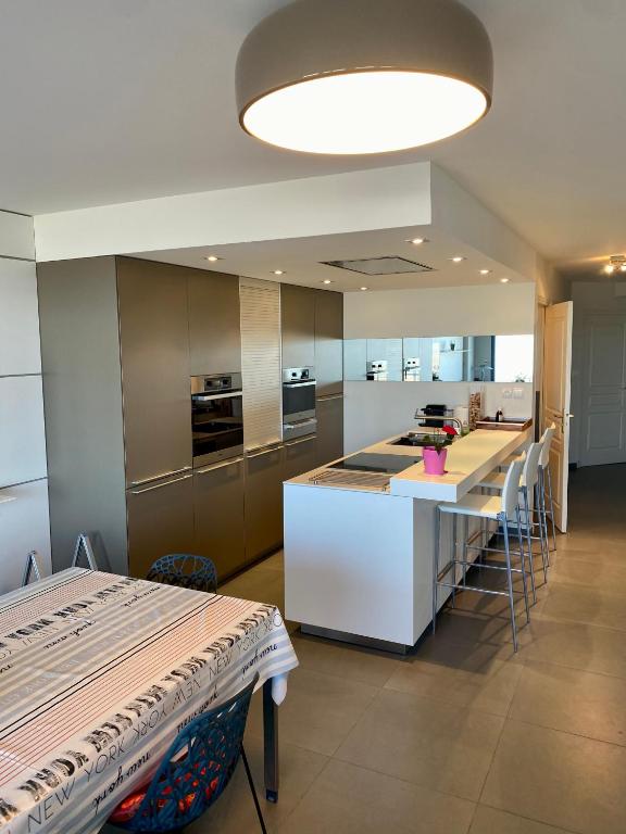 - une cuisine avec un grand îlot et un comptoir dans l'établissement Appartement de prestige vue mer place de parking, à Le Touquet-Paris-Plage