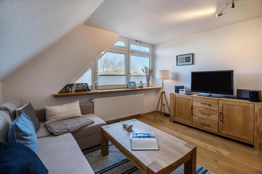 a living room with a couch and a tv at Ferienwohnung Uttied in Baltrum