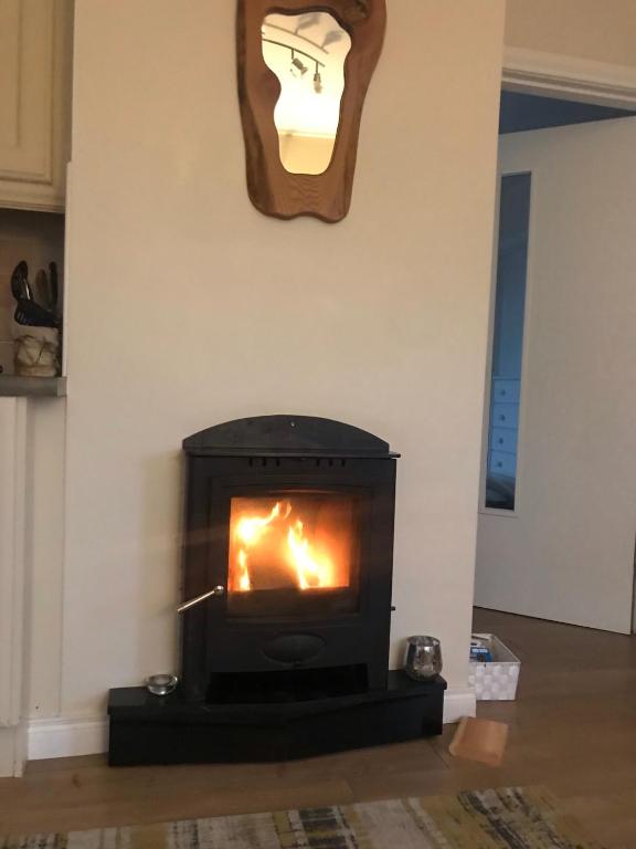 a fireplace in a living room with a fire at Village Way Apartments in Kincasslagh