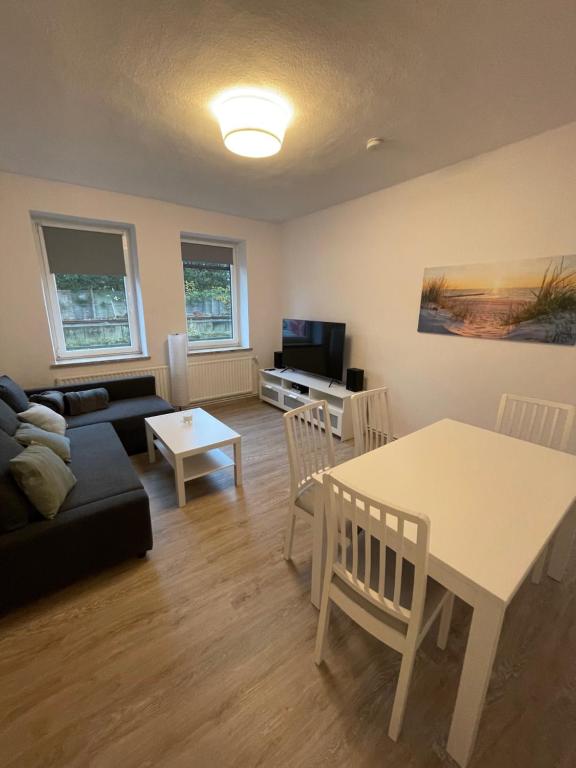 a living room with a black couch and a table at strandnahe 3-Zimmer Wohnung direkt am Yachthafen in Kiel