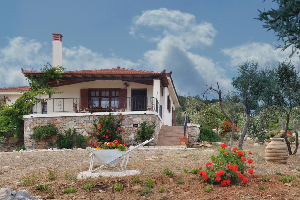 ein Haus mit einem Stuhl davor in der Unterkunft Villa Oceanis - Luxury Seaside Villa in Alonnisos Altstadt