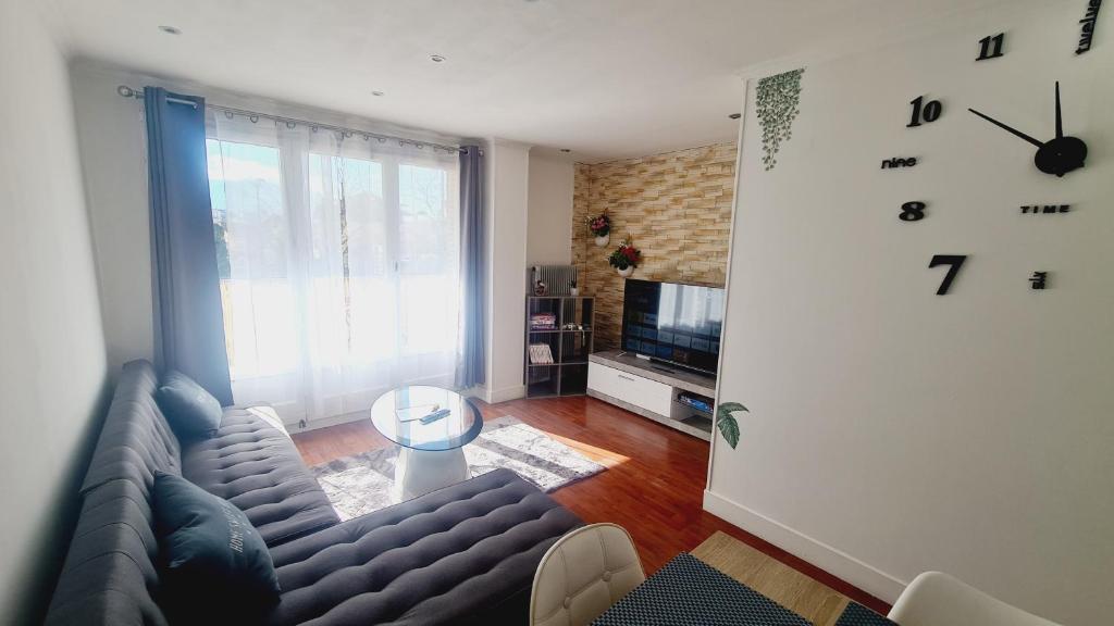 een woonkamer met een bank en een televisie bij Le Necy in Annecy