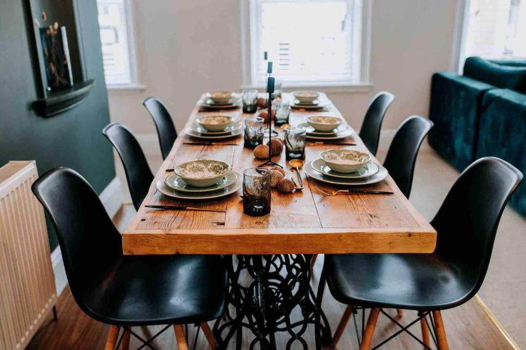 une grande table en bois entourée de chaises noires dans l'établissement Apartment22. A stylish and spacious Apartment in the heart of Historic Market town of Beverley., à Beverley