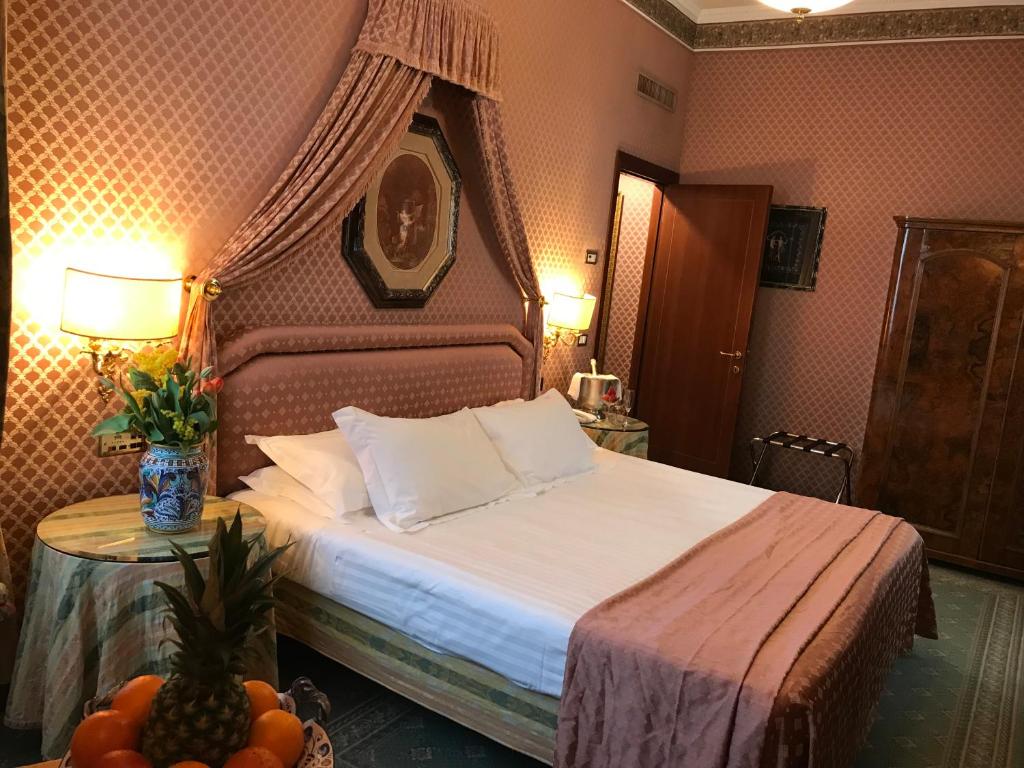 Postel nebo postele na pokoji v ubytování Hotel Mecenate Palace