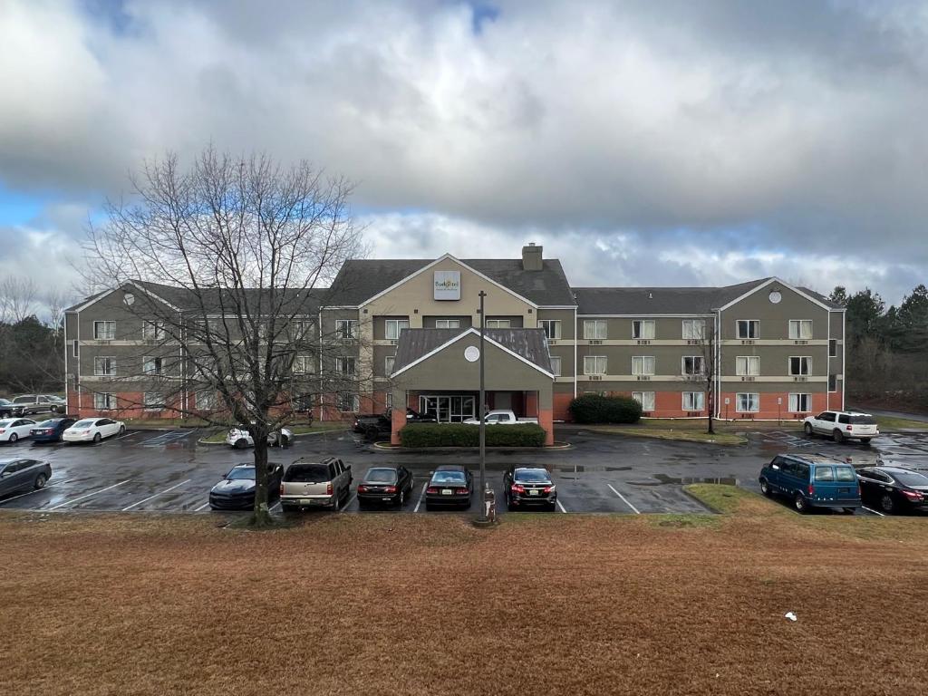 ein großes Gebäude mit Autos auf einem Parkplatz in der Unterkunft Budgetel Inns & Suites in Fairfield