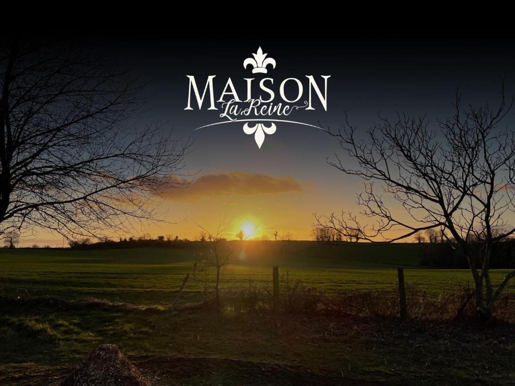 Ein Sonnenuntergang auf einem Feld mit dem Schild des Milson Institute in der Unterkunft Maison La Reine in La reine