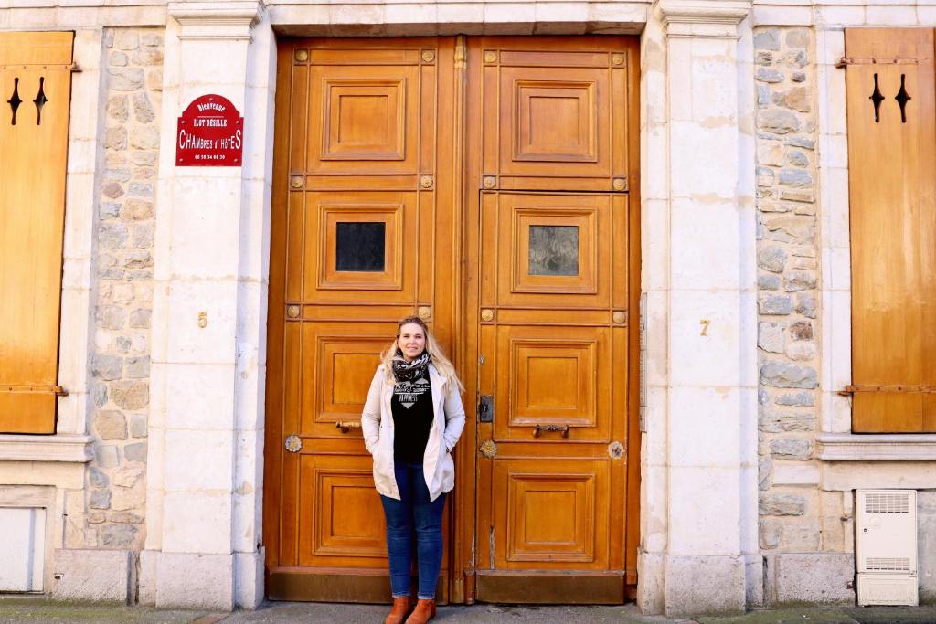 kobieta stojąca przed dużymi drewnianymi drzwiami w obiekcie Ilot Désille w mieście Boulogne-sur-Mer