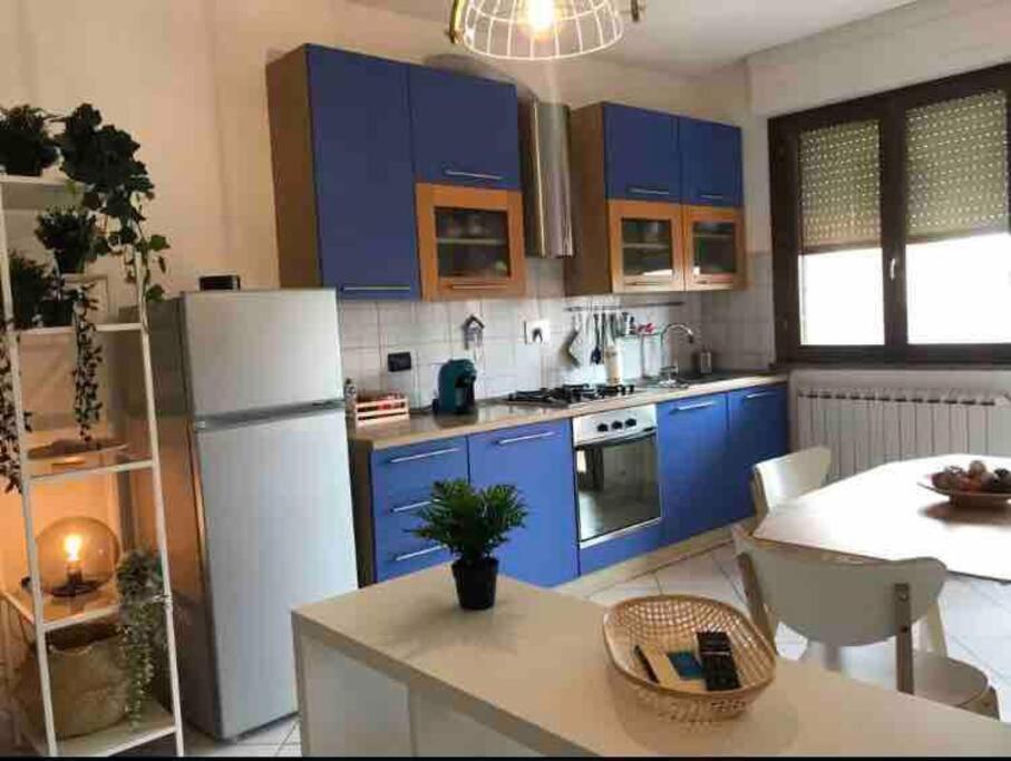 a kitchen with blue cabinets and a white refrigerator at Accogliente e spazioso appartamento a Cecina in Cecina