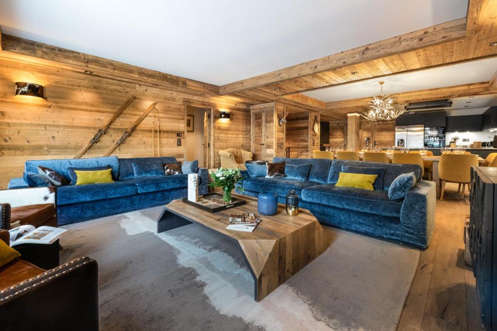 a living room with blue couches and a table at Alaska Lodge by Alpine Residences in Val-d'Isère