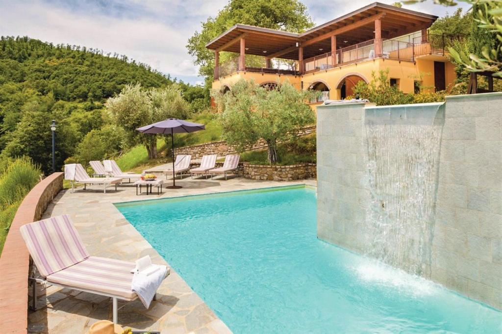 una piscina con sillas y una casa en Villa Montecastelli, en Niccone