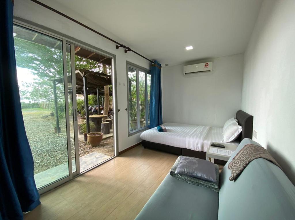 a bedroom with a bed and a sliding glass door at LeThuHouse in Melaka