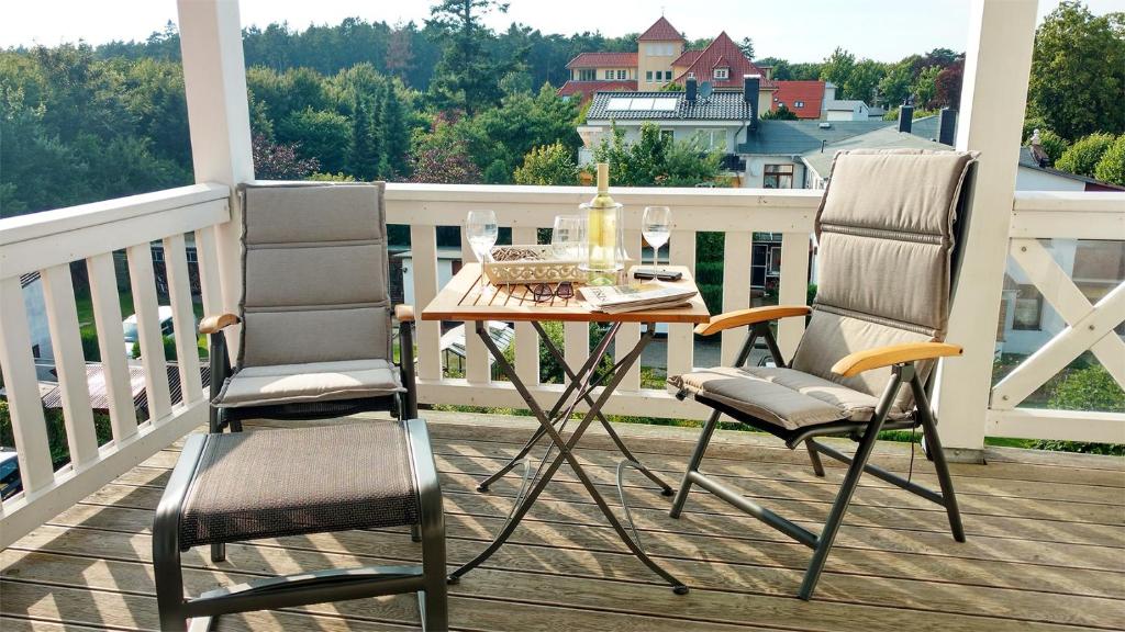 2 Stühle und ein Tisch auf einer Veranda mit Aussicht in der Unterkunft Ferienwohnung Parkblick Nr. 22 in Kühlungsborn