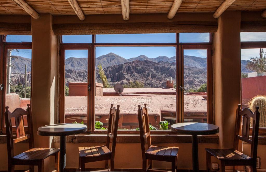 Habitación con sillas y ventana grande con vistas a las montañas. en Antigua Tilcara en Tilcara