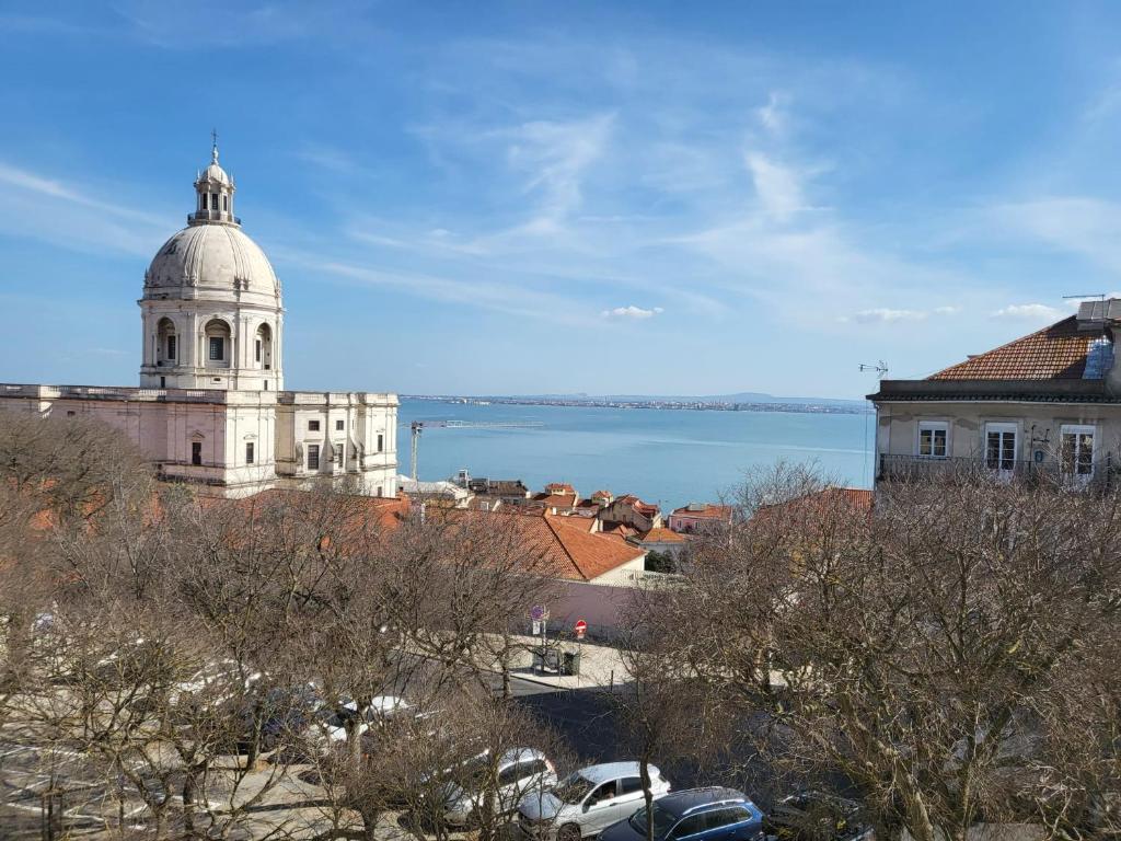 a building with a dome on top of it next to the water at Pilar - Alfama River View in Lisbon