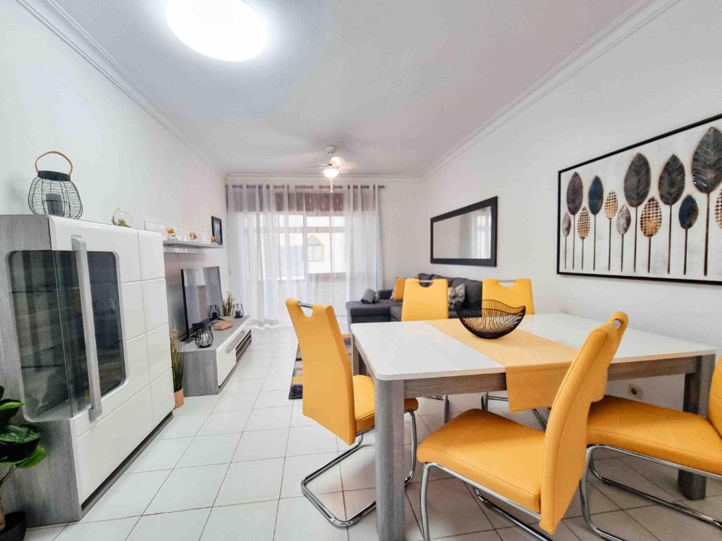 a dining room and living room with a table and chairs at Apartment Praia Rocha Candimar Sunflower in Portimão