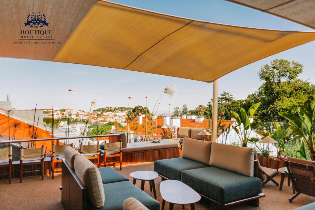 d'une terrasse sur le toit avec des canapés et des chaises. dans l'établissement The Vintage Hotel & Spa Lisbon, à Lisbonne