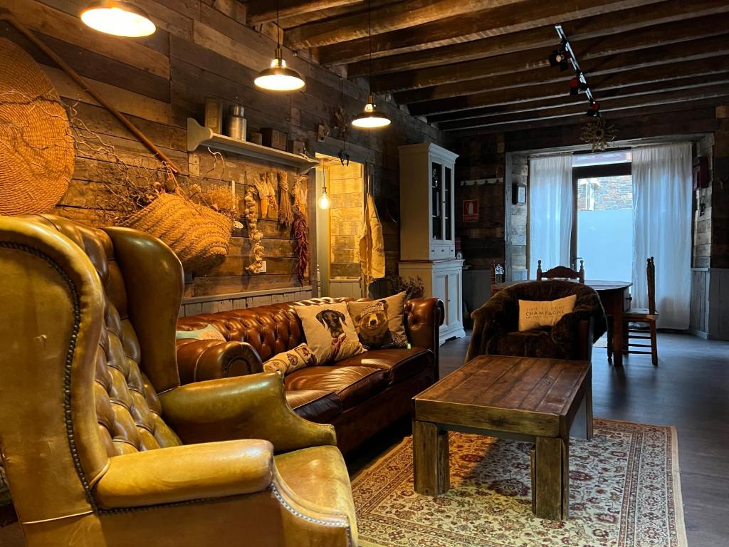 a living room with a leather couch and a table at Cabane Du Cerf in Llivia