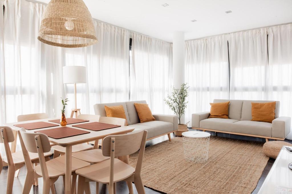 a living room with a table and a couch at Apartamentos FV Flats Valencia - San Felipe Neri in Valencia