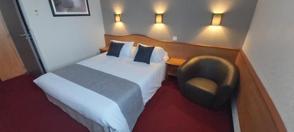 ビアにあるBrit Hotel Confort Villeneuve Sur Lotのベッドと椅子付きのホテルルーム
