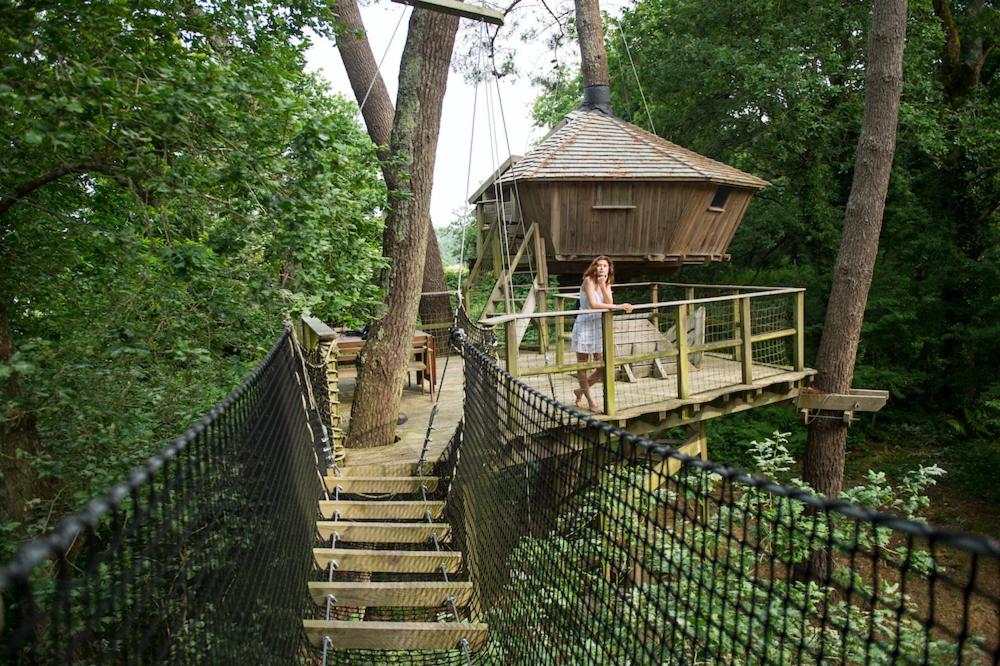 a woman standing on a platform in a tree house at Dihan Evasion in Ploemel