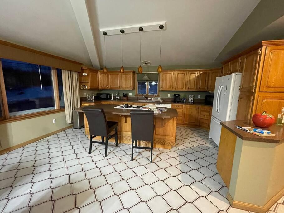 a kitchen with a table and chairs and a refrigerator at Luxury 3-Bedroom home in Caribou