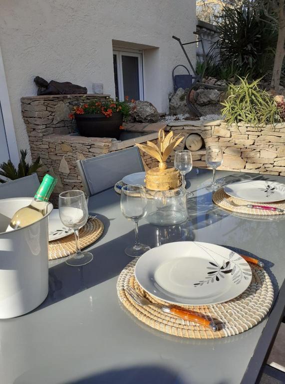 a table with plates and wine glasses on it at Gite La vallée du silence in Le Beausset