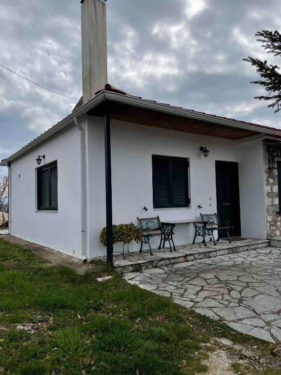 una iglesia blanca con dos bancos frente a ella en Villa Lochia - Ελαφοπήδημα, en Livádion