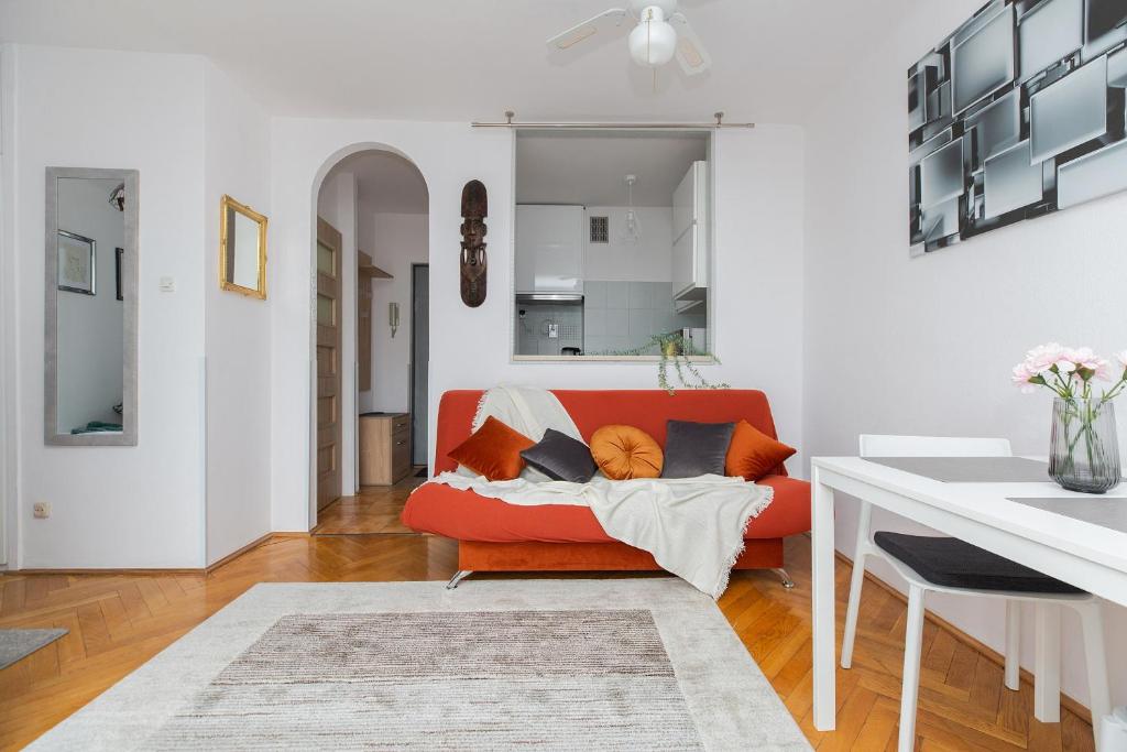 sala de estar con sofá rojo y almohadas en ShortStayPoland Chłodna (B74), en Varsovia