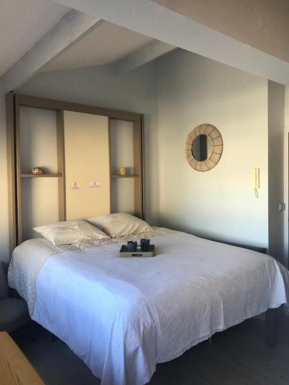 a bedroom with a large white bed with a mirror at Studio Le Sandettie à 50m de la plage! in Fort-Mahon-Plage