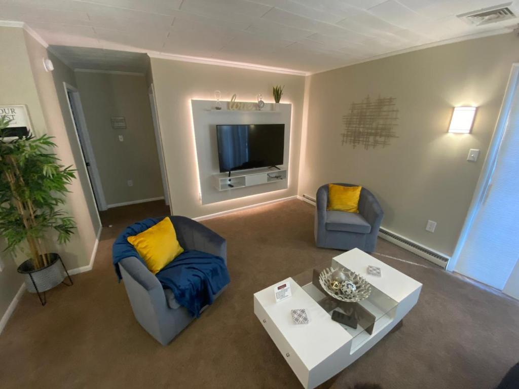a living room with two chairs and a tv at A Modern Apt close to downtown in Lancaster
